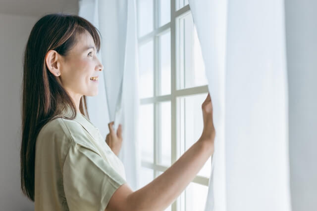 窓を開ける女性